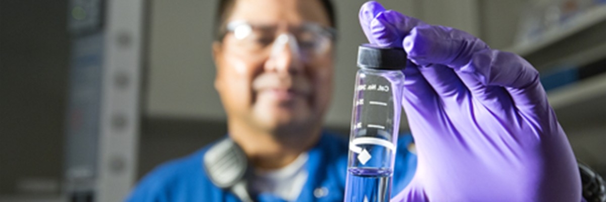 Man inspecting glass tube